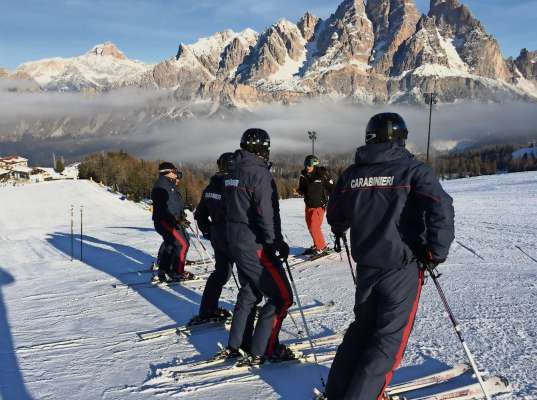 I carabiniere, co ra so mondura, su ra pistes da schie in Anpezo, parcé che podone ese dute pi segure.
