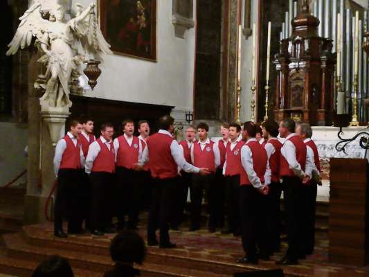 »El Coro Fodom entánt el conzert nte la gliejia de S. Stefen a Belum«.
