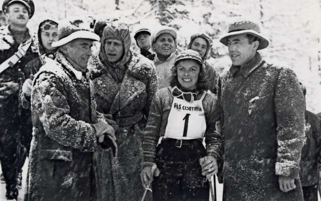 Celina Seghi de vinte ane, in Tofana, par i Mondiai de schie in Anpezo del 1941, intrà Raffaele Manganiello inalora presidente del Comitato olimpico talian, e Hans von Tschammer, presidente de el Comitato olimpico todesco.
