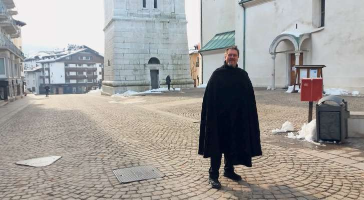 El pioan de Anpezo don Ivano Brambilla inze ra piaza voita del paes, senza parsones che pasa. Un pastor che i tende a 'l so rodol.
