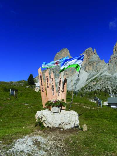 La bandiera ladina enlongia al monument a l'unità di ladins sul jouf de Sela.
