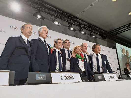 De śugno del 2019, in Svizera, daante al Comitato olimpico, ra scuadra de r'Italia r'à fato festa, par ra Olimpiades d'inverno del 2026 che ruaa a Milan e in Anpezo. Ancuoi 'l é calchedun che fesc outre conte.
