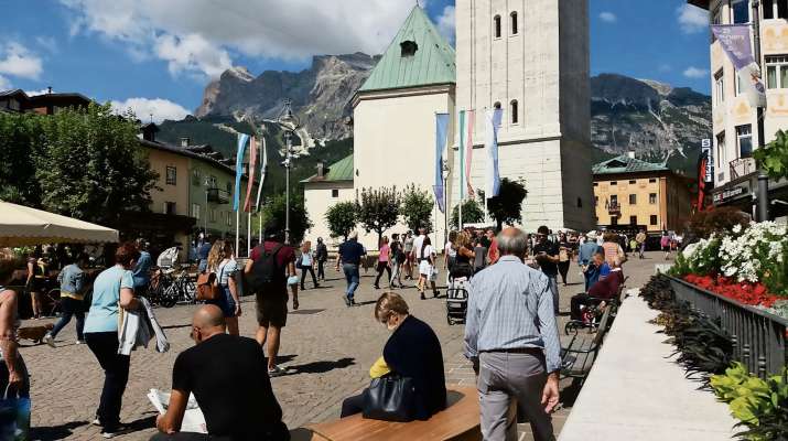 Ra piaza de Anpezo piena de parsones, che 's rua da duta r'Italia e da fora, a portà laoro e sode, ma anche calche festide par el doman.
