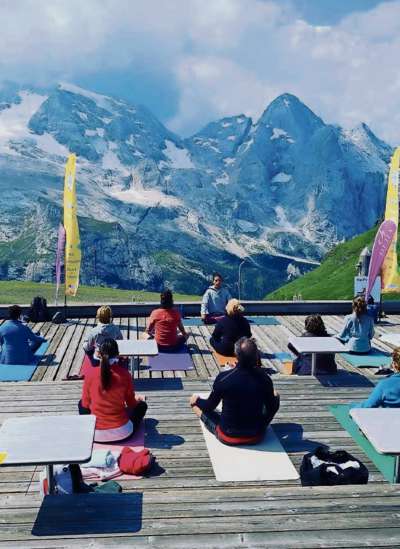 Yoga davánt a la Marmolada. Chësta una de le proposte turistiche per se adaté a le norme anticovid.
