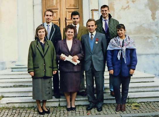 Inze chesta bela foto 'l é duta ra familia Suani, del 2001, canche in Anpezo s'aea saludà Corrado, che el lasciaa el so laoro de monego par ra parochia, dapò de cuaranta ane. Inze meśo, inpó i jenitore, intrà i fardiei, 'l é Giovanni, che inalora 'l ea poco pi de un tośato.
