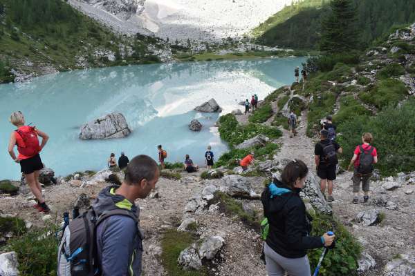 El lago Sorapisc, ra śente, ra graes agnó che ‘na ota ‘l ea ra jaza: un de i luoghe pi biei de ra Dolomites, ma propio par chesto rua masa śente e ‘l é da el precurà.
