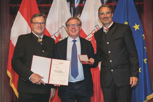 Da man ciancia: l presidënt dl Tirol Günther Platter, Oskar Insam de Sëlva cun la bedaia de merit y l presidënt de Südtirol Arno Kompatscher (foto: Land Tirol/"DieFotografen").
