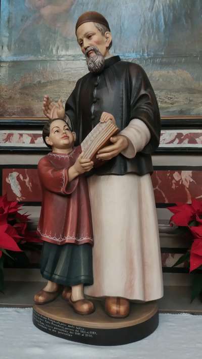 Una de ra doa statues de san Ujop Freinademetz che ‘l é inze ra jeja granda de Anpezo, de i sante Felipo e Iaco.
