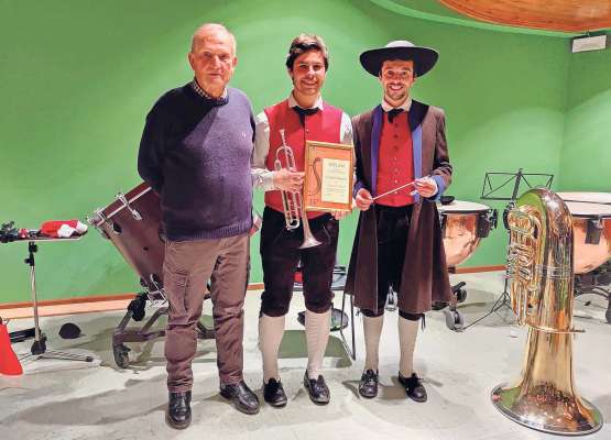 El prescident de la Bánda da Fodom Nani Pellegrini e l diretor Giuliano Federa (amc) con Davide Pellegrini, premié per 15 agn de ativité.
