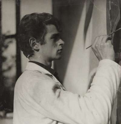 L’artist Georg Thuille pro le laur da depënje fora la capela Europa, 1964.
