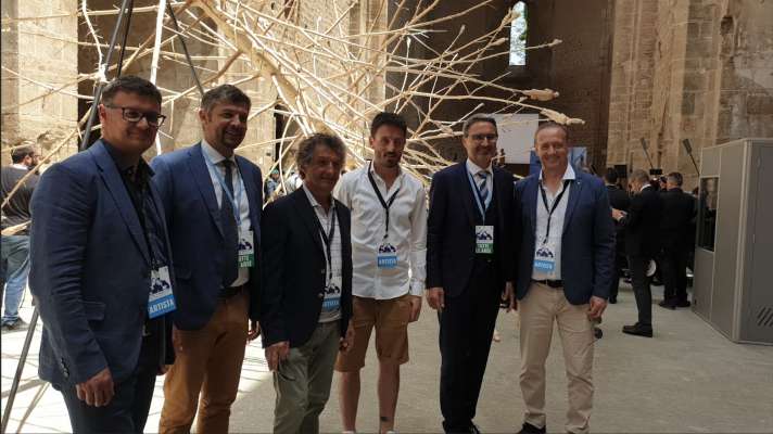 Da m.c.: l artist Gerald Moroder, l assessëur provincial ladin Daniel Alfreider, l artist Gregor Prugger, l artist Fabrizio "Biz" Senoner, l presidënt provinziel Arno Kompatscher y l artist Peter Demetz. Dovia: l lëur "L'albero di tutti" de Gregor Prugger (foto: ASP).
