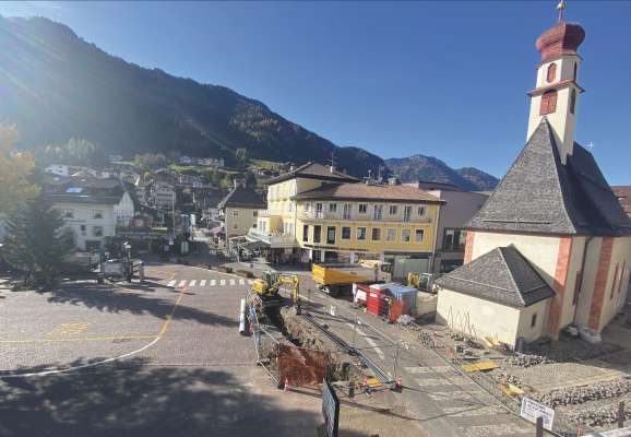 Sun Plaza de Sant Antone a Uritjëi. A man ciancia: l lën da Nadel, a man drëta i lëures che vën fac pra i sasc de salejà y pra la roles dal’ega.
