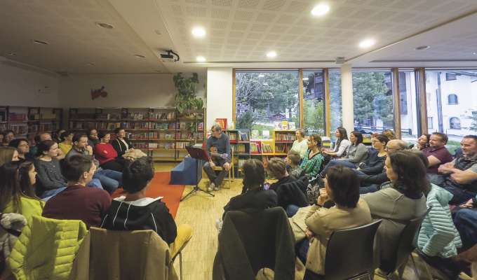 Markus Doggi Dorfmann cun na pert dl publich che ie unit a l scuté su tla biblio­ teca publica de Sëlva. Stuei, y nia uec, n fòvel mo truep d’autri.
