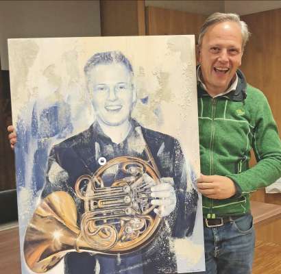 Egon Lardschneider cun si portrait fat dal artist Christian Stl Holzknecht.
