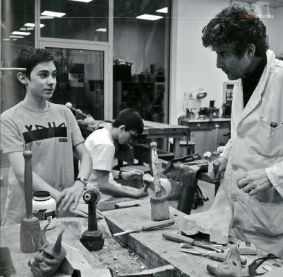 L professor Davide Deflorian te laboratorie con si studenc.

