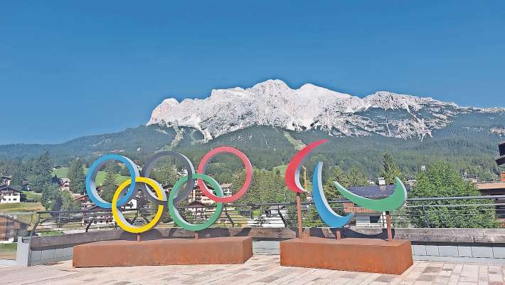 I »Spectaculars«, i zinche cerce de ra Olimpiades e i tre agitos de ra Paralimpiades, in piaza in Anpezo, i varda ra pistes de Tofana.

