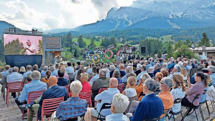 In piaza, sul sorei daerto intrà ra crodes, ra festa par ra storia de i inpiante, co i segne de ra Olimpiades e Paralimpiades 2026.
