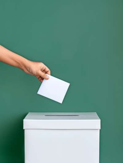 media/k2/galleries/29152/thumbs/hand-placing-ballot-paper-into-ballot-box-green-background_web.jpg