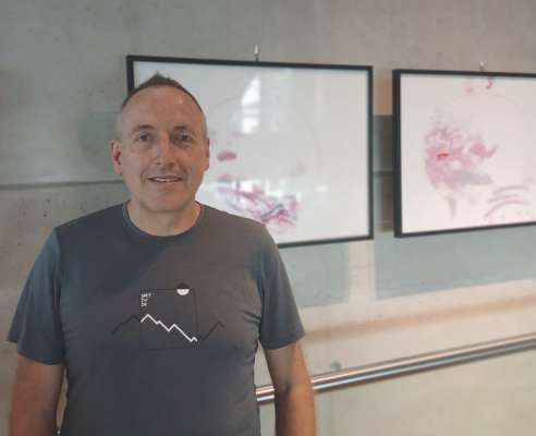 L artist Klaus Rungger dan si chedri tla biblioteca de Burnech.
