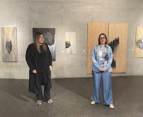Celine Silbernagl (a man drëta), cunseliera dla Lia Mostra d'Ert, à dat l bënunì ala artista Gaia Lionello (a man ciancia).
