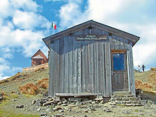 L bivaco, davántsu, e la capela, davo­via, su la ponta de Col de Lana.
