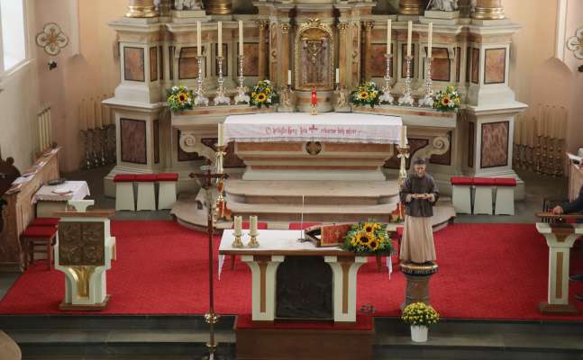 Le presbitere dla dlijia d’Al Plan. A man ciampa l’ambo nü, a man dërta dl alté la statua de Sant Ujöp Freinademetz.
