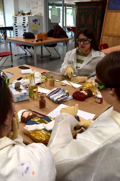 I studenc te laboratories à depent e endorà la fegures di doi profec.
