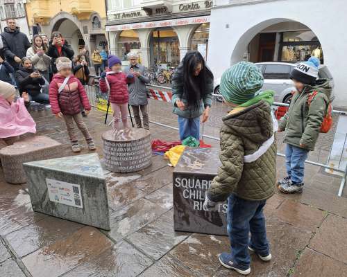 L monumënt sun Plaza de Chemun a Bulsan cun la scrites te cater rujenedes, nce per ladin. 
