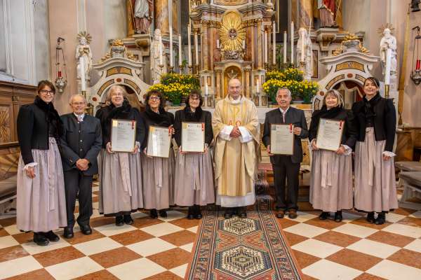 Dmc la dirighënta dl Cor Cristina Pitscheider, l’orghelist Paul Dapunt, Agnes Daprè, Elisabeth Ties y Frieda Daprè, siur degan Iaco Willeit, Walter Craffonara, Benedicta Pescoller y la presidënta dl Cor Susi Pitscheider. Foto: Freddy Planinschek. 
