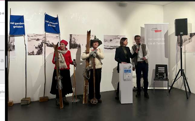 Pra la ntroduzion ala mostra duta tl sëni dl schi: n vëija doi schiadëures furnii cun l guant da zacan. Daujin iel la diretëura artistica dl Tublà da Nives, Martina Rier, y l presidënt dla lia di Culezionisć, numismatich y vedla chertes.
