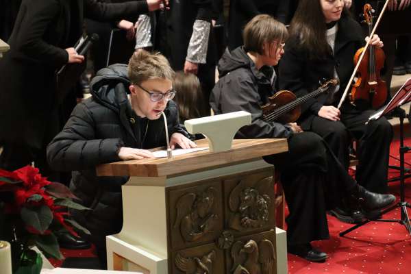 Elias Frontull &aacute; lit dant s&uuml;a storia en gaujiun dl conzert da Nad&eacute; cun i "Mosaic Singers & Players".
