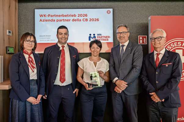 Nte la foto l moment de la consegna del recugnisciment a la Pordoi S.p.a. Da m&aacute;n ci&aacute;mpa: Alexandra Silvestri, consiad&euml;ssa del consei diretif de la Crousc Bl&aacute;ncia de Bols&aacute;n, Alexander Schmidt, prescident de la Crousc Bl&aacute;ncia, Sonia Dallo, vizeprescidenta de la pordoi S.p.a., Arno Kompatscher, prescident de la Provinzia de Bols&aacute;n e Ivo Bonamico, diretor de la Crousc Bl&aacute;ncia de Bols&aacute;n.
