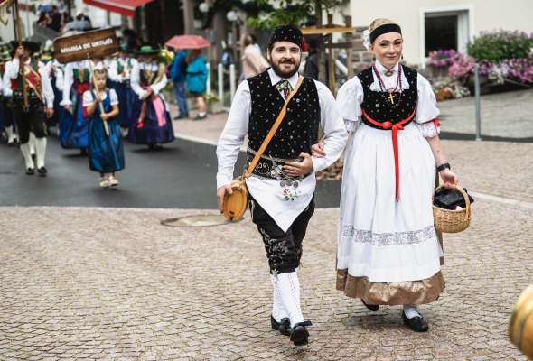 Per fertuna &agrave; l t&euml;mp iust lasci&agrave; f&eacute; la defileda. N v&euml;ija n bel per de doi j&euml;uni cun l guant tradiziunel. (FOTO Werner Dejori)
